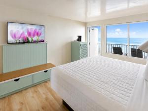 a bedroom with a bed and a view of the ocean at Palm & Tide Beachfront Hotel in Panama City Beach