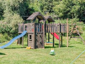 a wooden playground with a slide and a playset at Au Bonheur Nomade in Livry