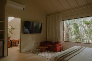 a bedroom with a bed and a chair and a window at Arde La Selva in Santa Fe de Antioquia