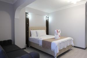 a bedroom with a bed with a chair and a couch at KILIÇ MOTEL in Istanbul