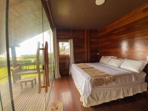 a bedroom with a bed and a glass wall at Pousada Delta Chalés in Tutóia +65 photos