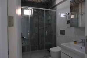 a bathroom with a shower with a toilet and a sink at KILIÇ MOTEL in Istanbul +45 photos