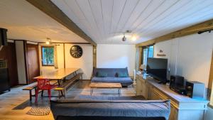 a living room with a couch a table and a tv at La carrouere in Gujan-Mestras