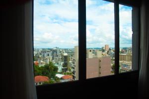 a view of a city from an open window at Swan Caxias do Sul in Caxias do Sul