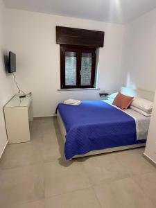 a bedroom with a blue bed and a window at Angelo in Futani