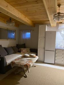 a living room with a couch and a table and a refrigerator at Agroturystyka Evita in Jabłeczna
