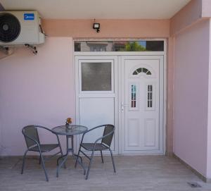 a table and chairs in front of a white door at N&L apartments in Strumica