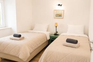 two beds in a room with white walls at Casa Duea Sorores in Osredina