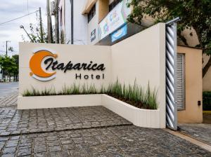 a sign for a hotel in front of a building at Hotel Itaparica in Caruaru