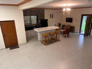 a large living room with a counter and chairs at Moksha farms -3bhk private villa with pool and nature in Pālghar