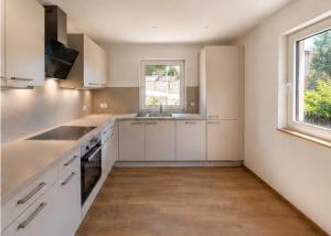 a kitchen with white cabinets and a sink and a window at Haus Anni in Ebermannstadt +14 photos