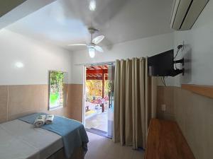 a bedroom with a bed and a sliding glass door at Mata Virgem Hostel e Pousada in Abraão