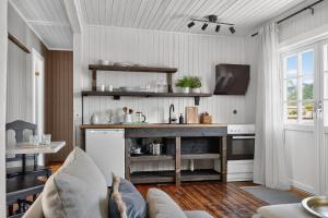 a kitchen with a table and a couch in a room at Astra Village - Waterfront Rorbu Cabins in Lofoten in Kabelvåg