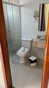 a bathroom with a toilet and a glass shower at Villarejo Parque Hotel in Penha
