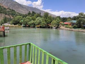 a view of a river with a wooden bridge at Fish Lake Park Guest House in Chitral
