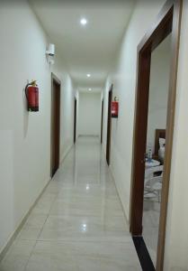 a hallway of a hotel with doors and a long corridor at Hotel shine plus in Kurukshetra