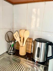 a kitchen counter with wooden spoons and a tea kettle at Serenity homes Uganda in Mbale