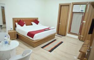 a bedroom with a large bed with red pillows at Hotel shine plus in Kurukshetra