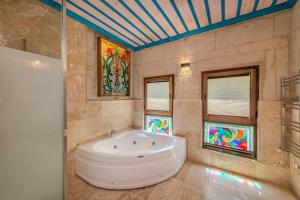 a bathroom with a tub and stained glass windows at Arcus Cappadocia in Göreme +59 photos