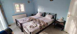 a bedroom with two beds with white sheets and a window at Casa de Calma in Argostoli +47 photos