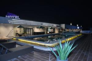 a swimming pool at night with a hotel at lovera hotel in Santiago de los Caballeros