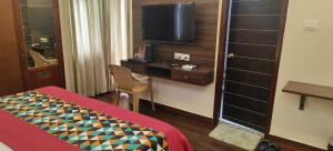 a hotel room with a bed and a television at Narayan Palace- Luxury Homestay in Varanasi