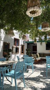 a group of blue tables and chairs under a tree at Ados Hotel in Çeşme