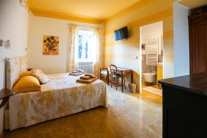 a bedroom with a bed and a table and a bathroom at Carlo Alberto B&B in Gavi