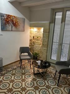 ein Wohnzimmer mit zwei Stühlen und einem Tisch in der Unterkunft Li Cafari in Aradeo