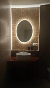 a bathroom with a sink with a round mirror at Villa Maiseli in Ambrolauri