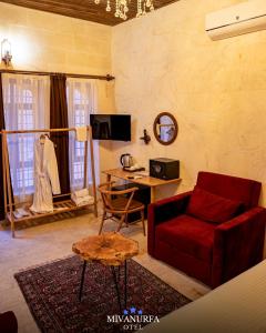 a living room with a red couch and a desk at MivanUrfa Otel in Urfa
