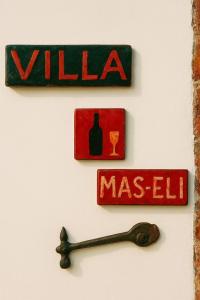 a wall with two signs on a wall with a wine bottle at Villa Maiseli in Ambrolauri
