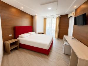a hotel room with a bed and a flat screen tv at Shala Resort & SPA in Durrës