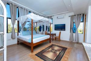 a bedroom with a canopy bed and a table at Diani Luxe Villa in Galu +39 photos
