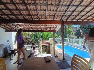 a group of women standing around a table next to a pool at Mata Virgem Hostel e Pousada in Abraão