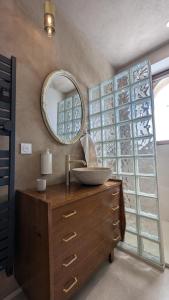 a bathroom with a sink and a mirror on a dresser at Château Foncine in Foncine-le-Bas