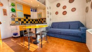a living room with a blue couch and a kitchen at Edelweiss - Maison dOc in Oulx