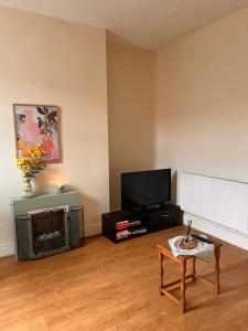 a living room with a tv and a table at The Blackburn 2 Bedroom House in Cherry Tree