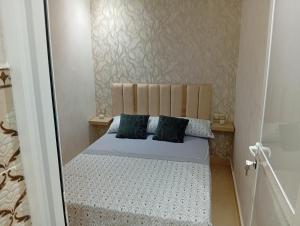 a small bedroom with a bed with two pillows at BENYOUNECh in Belyounech 