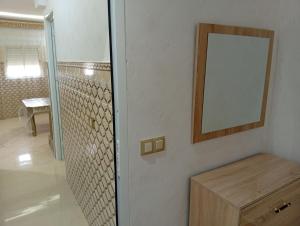 a bathroom with a mirror and a wooden cabinet at BENYOUNECh in Belyounech 