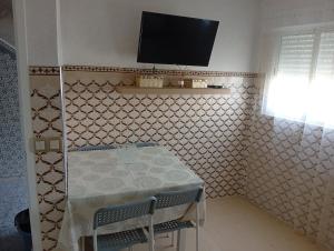 a room with a table and a tv on the wall at BENYOUNECh in Belyounech 