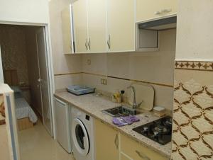 a kitchen with a sink and a washing machine at BENYOUNECh in Belyounech 