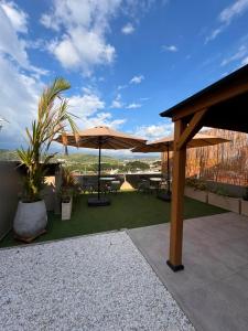 a patio with tables and umbrellas on a roof at Treeloft Home in Girón