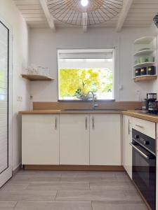 a kitchen with white cabinets and a window at Edenbluetropical in Le Moule