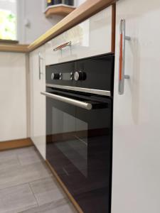 a kitchen with a black oven in a kitchen at Edenbluetropical in Le Moule