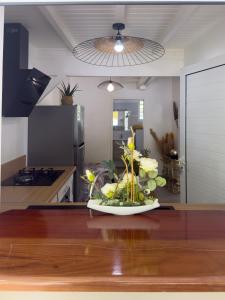 a plate with flowers on a table in a kitchen at Edenbluetropical in Le Moule