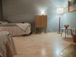 a bedroom with a bed and a table and a lamp at Heritage House at Villa Sofia in Lahti