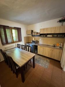 a kitchen with a wooden table and chairs in a room at Chata Biela Stopa in Tatranská Lomnica