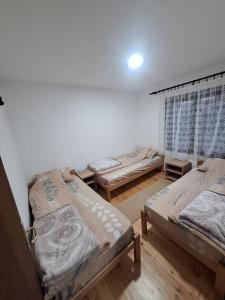 a room with three beds and a window at Radnicki smestaj in Prilike