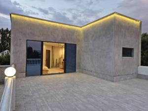 a house with a large glass door on a patio at Villa by HomeLand in Khujand